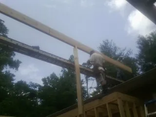 Carpenter setting a ridge beam over a new addition frame — Ice Dam Removal by Roofing Brothers in Downey